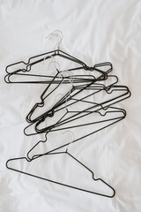 Wall Mural - Lots of hangers on white linen cloth. Minimalist fashion, wardrobe, clothes concept. Flat lay, top view