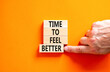 Time to feel better symbol. Concept words Time to feel better on wooden block. Beautiful orange table orange background. Businessman hand. Motivational business time to feel better concept. Copy space