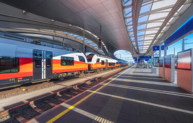 Wall Mural - high speed train on the modern railway station at sunset in graz, austria. beautiful orange intercit