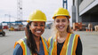 © Andy Dean - Two Smiling Young Adult Multiethnic Female Workers Wearing Hard Hat and Safety Vest Standing at a Shipping Dock - Generative AI.