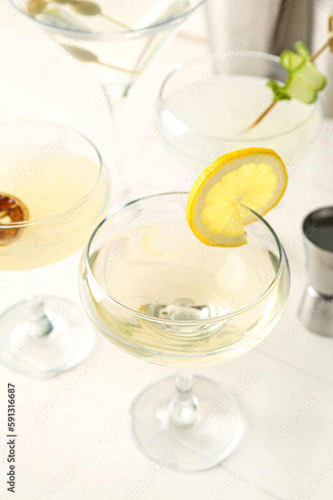 Glasses of tasty martini and lemon on light wooden table