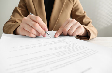 Wall Mural - Woman signing document at table, closeup view