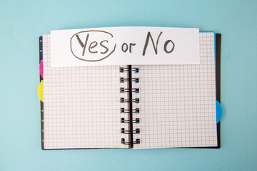 Wall Mural - top view open copybook with yes or no note on a blue background color notepad school lessons study s