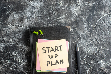 Wall Mural - top view start up plan note on sticker with copybook on a gray background lesson student note school