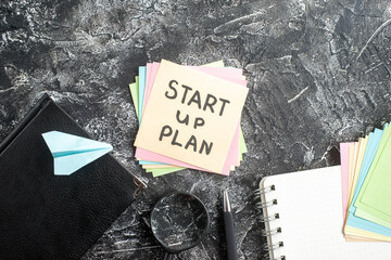 Wall Mural - top view start up plan note on sticker with copybook on a gray background lesson student notepad not