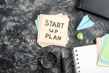 Wall Mural - top view start up plan note on sticker with copybook on gray background lesson student note school s