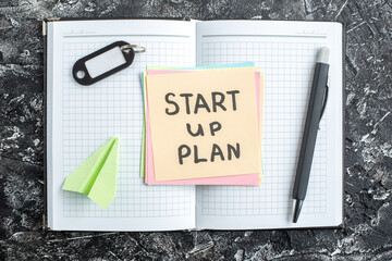 Wall Mural - top view start up plan note on sticker with copybook on gray background lesson student notepad note 