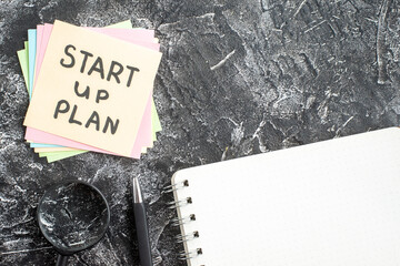 Wall Mural - top view start up plan note on sticker with copybook on gray background lesson student notepad note 
