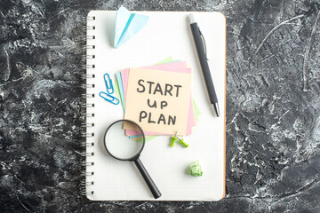 Wall Mural - top view start up plan note on sticker with pen and magnifier on gray background lesson student note