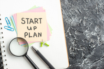 Wall Mural - top view start up plan note on sticker with pen and magnifier on gray background lesson student note