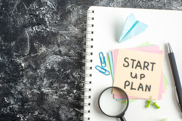 Wall Mural - top view start up plan note on sticker with pen and magnifier on gray background lesson student pape