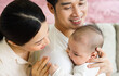 © 1112000 - Smiling mother and father holding newborn son at home