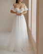 Trendy classic long wedding dress with cleavage and wide short sleeves decorated with floral lace. Bride in the shoulderless white wedding dress with deep neckline and fancy sleeves