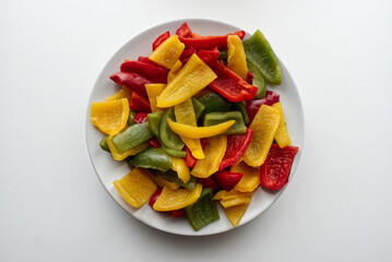 Wall Mural - Fresh colored pepper salad in a white dish. Top view