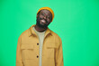 © pressmaster - Portrait of African American man in stylish clothing smiling at camera standing against green background