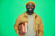 © pressmaster - Portrait of African American man holding books and smiling at camera standing on green background