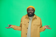 © pressmaster - Portrait of African American man spreading his hands in doubt looking at camera while standing on green background