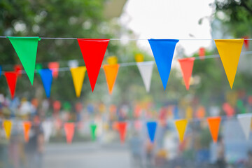 Decorative multi-colored triangle flags against the background at the festival in Thailand.