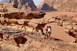 close view of two tourists on rocks visiting wadi rum desert