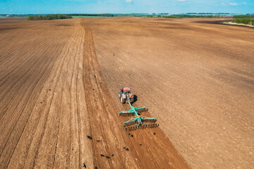 Wall Mural - Aerial View. Tractor Plowing Field In Spring Season. Beginning Of Agricultural Spring Season. Cultivator Pulled By A Tractor In Countryside Rural Field Landscape.