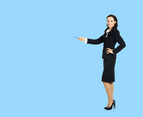 Sticker - Full body length size view of happy excited smiling businesswoman showing pointing advertise at copy space. Confident business woman in black suit standing on sky blue background.