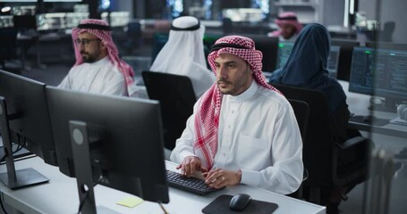 Team of Talented Young Middle Eastern Professionals Working in a Technological Research and Development Agency. Computer Screens with Software Code and Technical Neural Network Diagrams