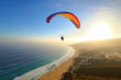 © ADDICTIVE STOCK - Generative AI illustration of distant person flying on parachute over blue sea water and sandy beach against cloudless sundown sky