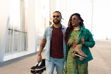 Cheerful couple with roller skating outside. Fun sexy boyfriend and girlfriend walking through the city.