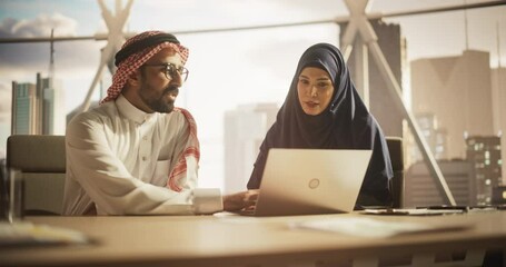 Poster - Female and Male Middle Eastern Colleagues Working in a Business Software Development Company. Muslim Specialists Using Laptop, Updating Economic Strategy Based on Financial Market News and Trends