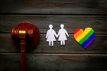 LGBT couple - two women paper shapes with judges gavel. LGBT social rights concept.