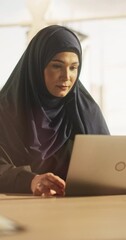 Poster - Vertical Screen: Empowering Portrait of a Muslim Businesswoman Wearing a Hijab, Working on Laptop in a Company. Arab Financial Analyst Conducts Research in Emerging Middle Eastern Stock Market