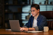 © Prostock-studio - Happy young businessman working in dark empty office