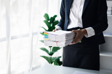 Wall Mural - Businessman holding a lot of documents, corporate financial documents, monthly financial summary documents. Concept of document management in the organization.