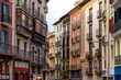 PAMPLONA, SPAIN - JULY 04, 2022: Pamplona, Navarra, SPAIN. The beautiful streets of the city of Pamplona. Beautifully coloured buildings with flowers of different colours, hanging from the balconies.
