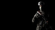 © Arsentyev Vladimir - A masked soldier holds a rifle in his hands on a black background, alone
