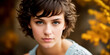 © Sergiy - Young beautiful brunette girl with short dark curly or wavy brown hair with a confident gaze, outdoor close-up and blurred autumn background with orange tree leaves. Generative AI.