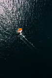 Fototapeta Nowy Jork - Top down aerial view of orange sailboat in water