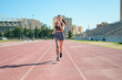 © Cristian Blázquez - Young athletic girl with tattoos runs around a running track