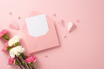 Wall Mural - Top view stylish flat lay photo of open envelope with blank card, pretty carnation blooms, and pink paper hearts on a soft pink background