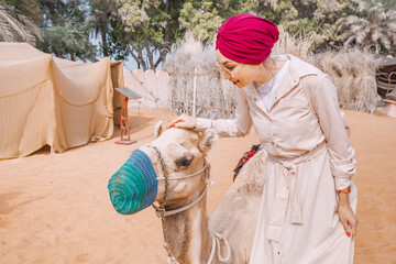 Wall Mural - Explore the wonders of a foreign land with a brave and adventurous Indian woman, as she rides her camel through the ancient and historic alleys of an Arabic heritage village.