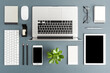 © One Pixel Studio - Office desktop with laptop and business accessories on gray background. Modern workspace concept. Top view