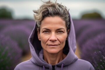 Wall Mural - Portrait of senior woman standing in lavender field smiling at camera