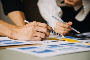 Close up ux developer and ui designer brainstorming about mobile app interface wireframe design on table with customer breif and color code at modern office.Creative digital development agency