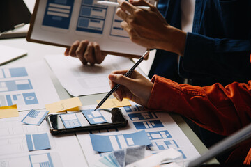 close up ux developer and ui designer brainstorming about mobile app interface wireframe design on t