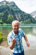 © Designpics - Portrait of mature man skipping stones at Lake Vilsalpsee, Tannheim Valley, Austria