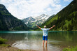 © Designpics - Backview of mature man with arms stretched outward, standing in Lake Vilsalpsee, Tannheim Valley, Austria