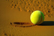 © jr-art - neon yellow tennis ball lies on brown sand ground. Generative AI