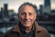 © Robert MEYNER - Portrait of a happy senior man smiling at the camera with a city in the background