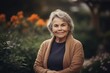 © Robert MEYNER - Portrait of smiling senior woman standing in the garden. Mature woman with gray hair.