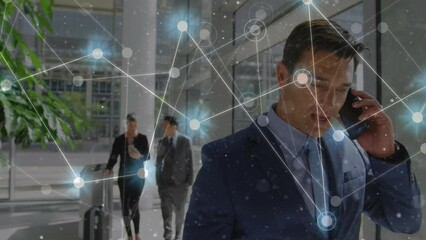 Canvas Print - Animation of network of connections against caucasian businessman talking on smartphone at office